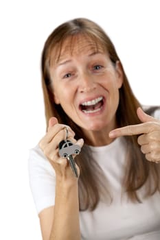 happy woman to point at her own car key and car on a key ring in the hand, isolated on white