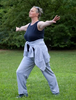 Senior woman doing Tai Chi against Outdoors