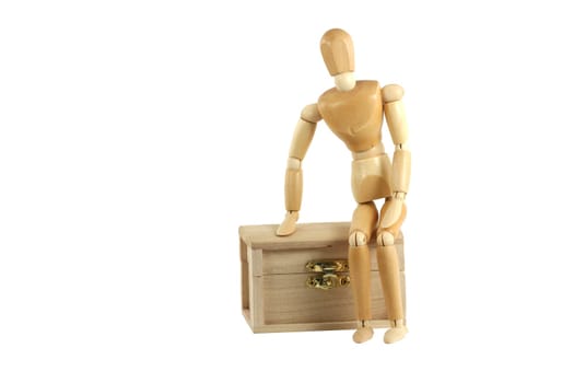 A Wooden manikin sitting on treasure chest