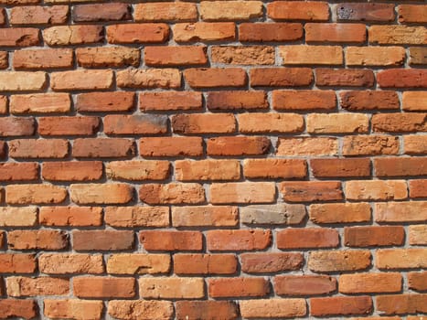Old weathered brick wall in Multi-Colored red shades.