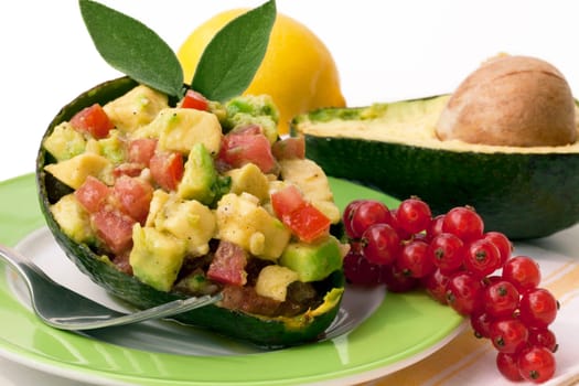 Avocado salad served with tomatoes,lemon and red currants