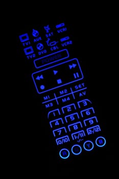 A Isolated lighted  TV remote control on black