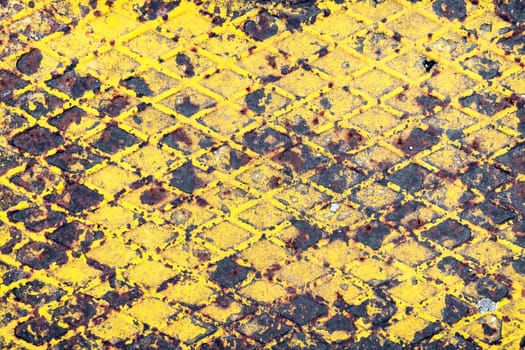 Corroded metal background. Rusted yellow painted metal plate.  The metal surface rusted spots. Rystycorrosion.