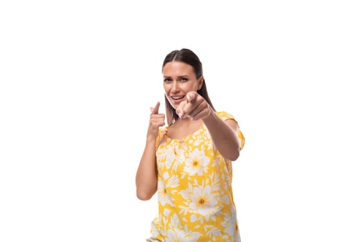 30 year old brunette woman dressed in a summer outfit rejoices on a white background with copy space.