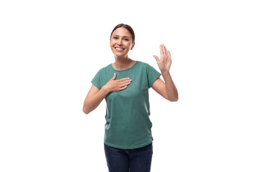 charming cute friendly slim young brunette woman dressed in a green t-shirt smiling on a white background.