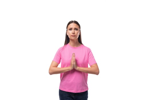 young pensive model woman with straight black hair dressed in a pink t-shirt is excited.