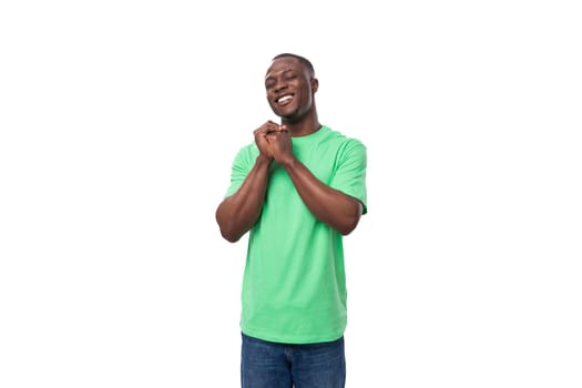 young american man dressed in a green corporate t-shirt on a white background with copy space.