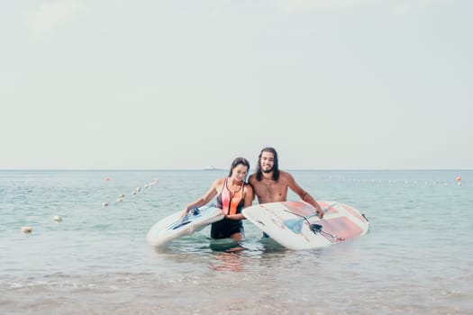 Close up shot of beautiful young caucasian woman with black hair and freckles looking at camera and smiling. Cute woman portrait in a pink bikini posing on a volcanic rock high above the sea