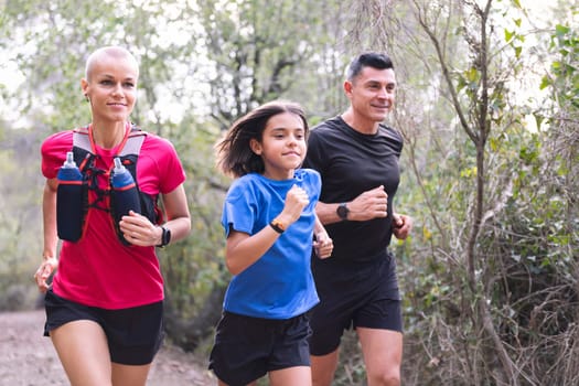 portrait of a family practicing trail running in the forest, concept of sport in nature and healthy family lifestyle