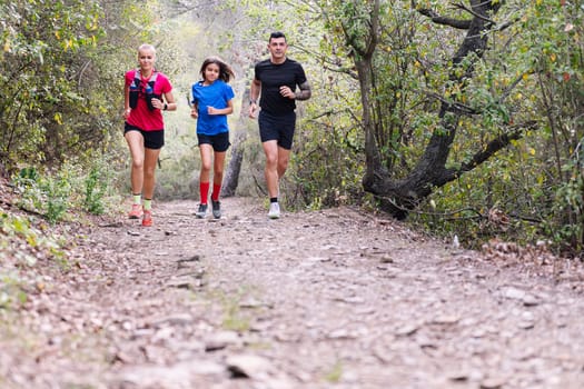 family practicing trail running in the forest, concept of sport in nature and healthy family lifestyle, copy space for text