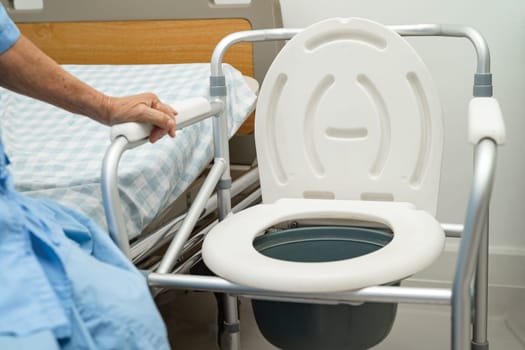 Flush toilet and shower chair in bathroom for old elder people.