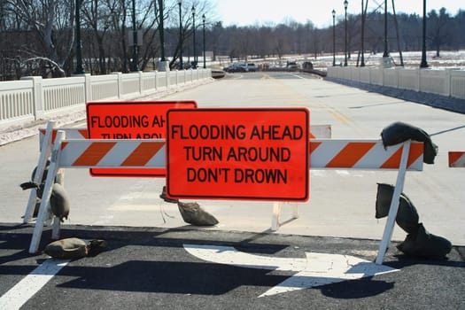 A Flooded roadway sign on a bridge