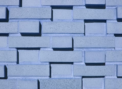 A pastel blue multi-layered and multi-sized brick wall.
