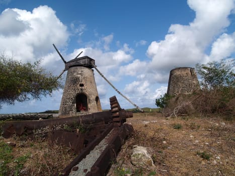 Old gears in front of an old windmill on Bettys Hope Plantation near Seatons, Pares on Antigua Barbuda in the Caribbean Lesser Antilles West Indies.