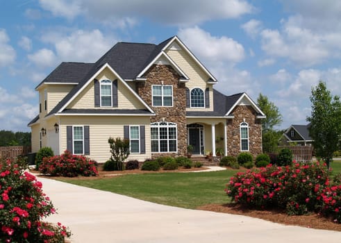 Two story residential home with both stone and board siding on the facade.