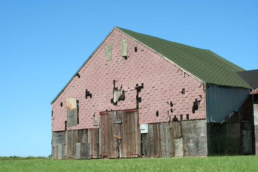A Old barn with grass and blue sky