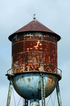 A Old rusty watertower against blue sky
