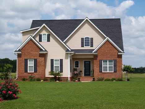 Two story residential home with both brick and board siding on the facade.