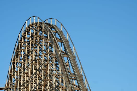 Wooden roller coaster against blue sky