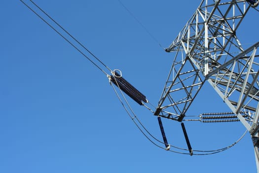 Power line tower against blue sky