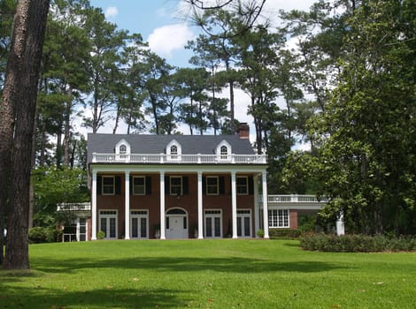Two story residential, historical, south GA home with brick facade and white columns.