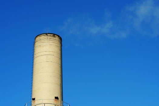 A smokestack against blue sky