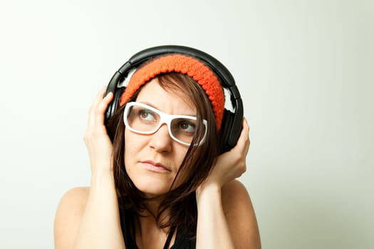 Young woman listening music with headphones. Studio shot.