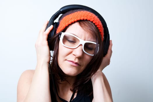 Young woman listening music with headphones. Studio shot.