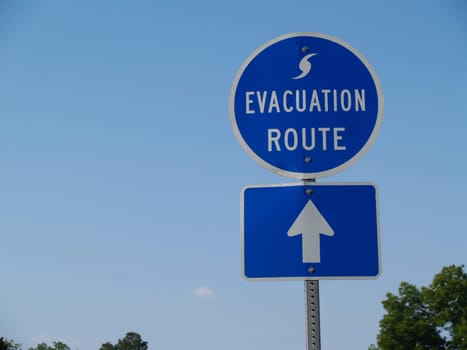 Blue hurricane evacuation route sign along a highway.