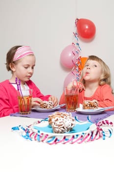 Girls having a traditional finnish May Day celebration, eating funnel cake, tippaleipa and drinking mead, sima