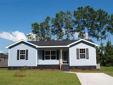Powder blue low-income single-story home with porch.