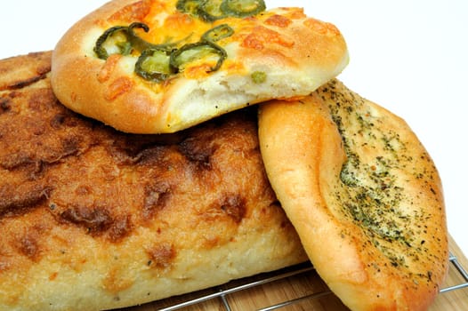 A square loaf of artisan bread and Focaccia rolls in cluding Italian herb and Jalapeno cheddar cheese