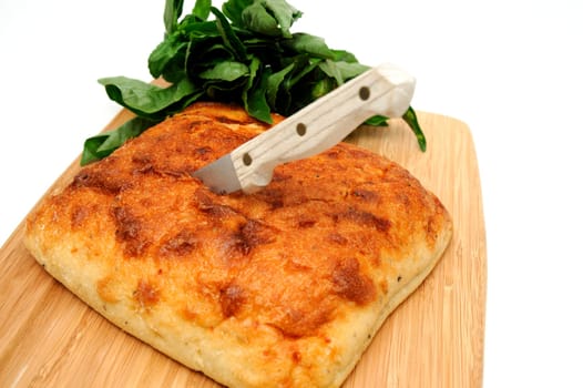 A square loaf of artisan bread ready to be sliced on a wooden cutting board