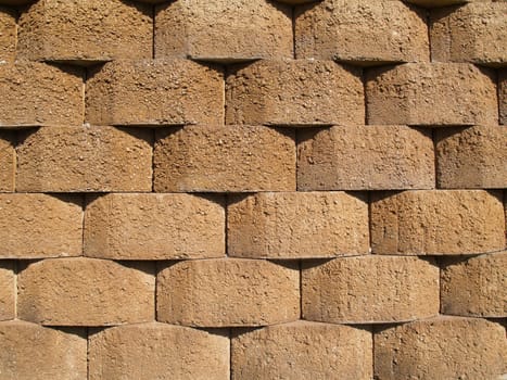 Rows of tan stone blocks that make up a retaining wall.