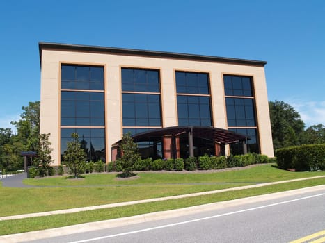 Three story office building with mostly glass front and an awning over the front walk.