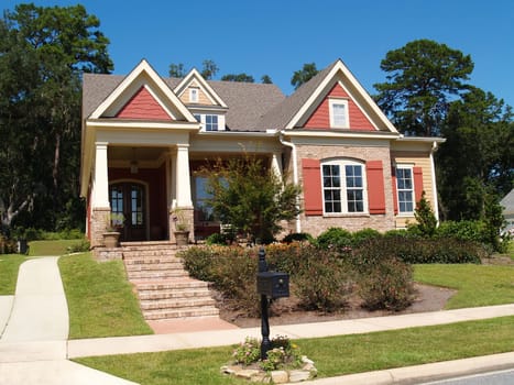 Beige brick home having peach and white trim with steps leading up to squares columns on the porch.
