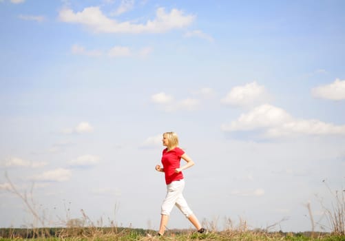 Young woman jogging on a dirt road