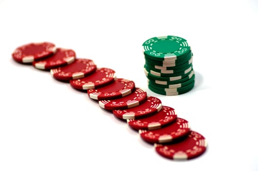 Green and red poker chips on a white suface