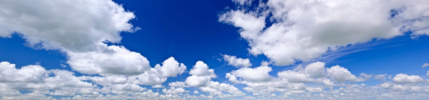 Panoramic background of blue sky with white cumulus clouds