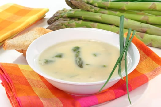 a bowl of asparagus cream soup with fresh ingredients