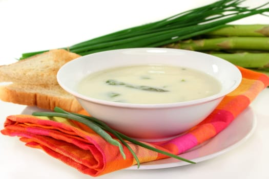 a bowl of asparagus cream soup with fresh ingredients