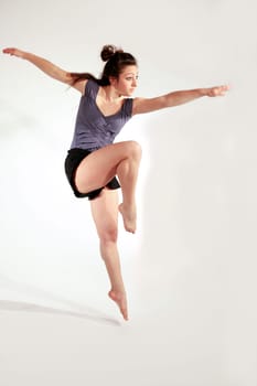 Young pretty teenage girl brunette dancing in studio with long hair