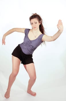 Young pretty teenage girl brunette dancing in studio with long hair