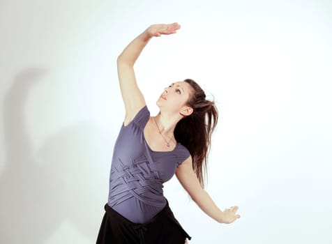 Young pretty teenage girl brunette dancing in studio with long hair