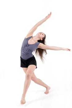 Young pretty teenage girl brunette dancing in studio with long hair
