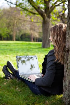Woman sitting in park with a new laptop