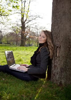 Woman sitting in park with a new laptop