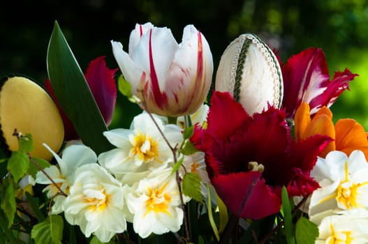 Bouquet of spring flowers (daffodils and tulips) with Easter eggs