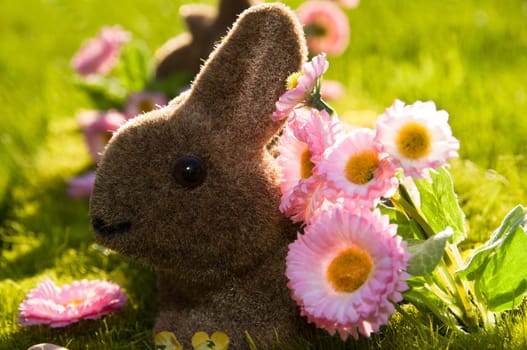 Faked Easter bunny on a beautiful spring meadow with daisies