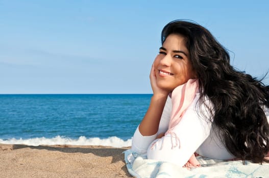 Portrait of beautiful smiling native american girl laying at beach
